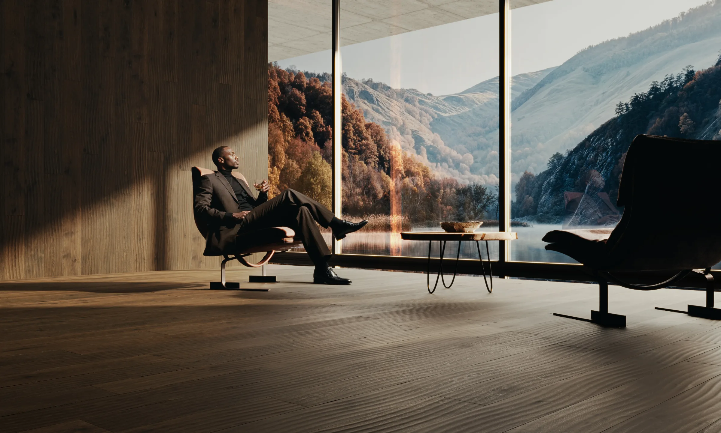 A man relaxes in a chair beside a panoramic mountain view.